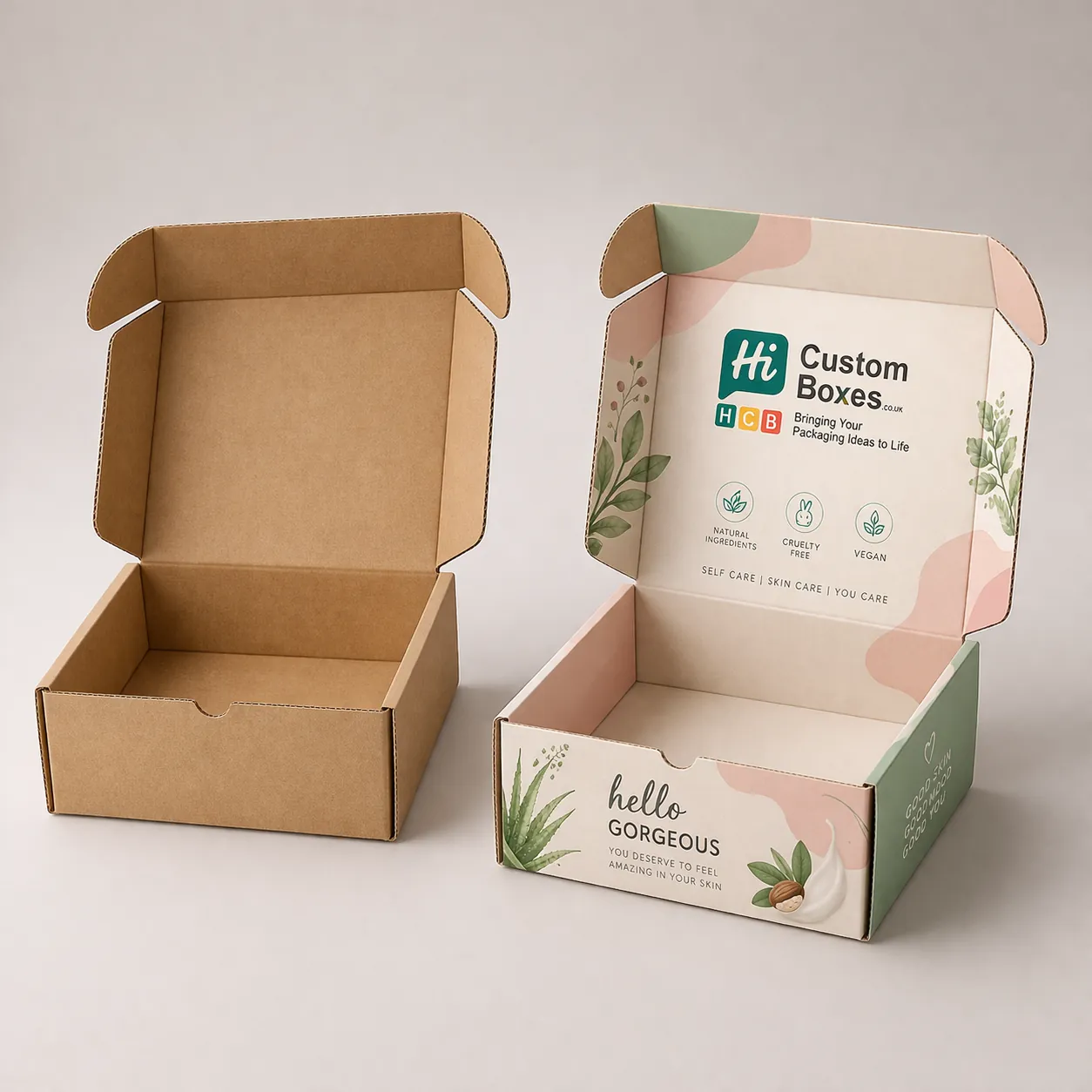 Two open corrugated mailer boxes, one natural brown Kraft and one featuring pink floral branding designs. class=